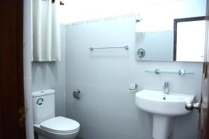 a white bathroom with a toilet and a sink at Anuradhapura Stay Apartments in Anuradhapura +27 photos