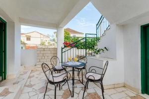 a patio with a table and chairs on a balcony at House Dinko in Vinišće