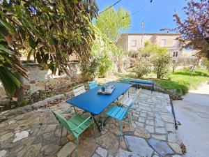 a blue table and chairs on a stone patio at Elegante maison avec un beau jardin, à 150 m de la mer, climatisation, Wifi ... in Saint-Mandrier-sur-Mer