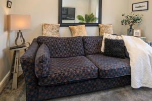 a living room with a blue couch with pillows at Poet's Cottage Wonderful Cottage In The Welsh Valleys by STAE-Homes in Aberdare