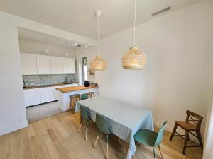 a kitchen and dining room with a table and chairs at Elegante maison avec un beau jardin, à 150 m de la mer, climatisation, Wifi ... in Saint-Mandrier-sur-Mer