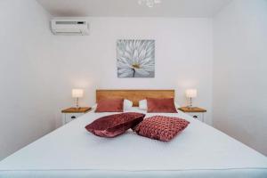 a bedroom with a white bed with two pillows at Apartments Sandra in Okrug Donji