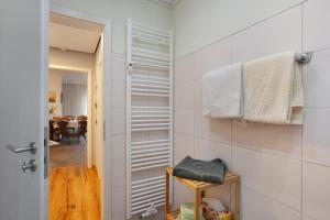 a bathroom with white tile walls and a hallway at Birkenhauer inkl Meine Card plus in Willingen +14 photos
