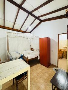 Zimmer mit einem Bett, einem Tisch und einem Spiegel in der Unterkunft Kisandu guest in Mirissa