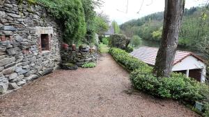 a stone building with a pathway next to a tree at Chez Nicole et Patrick in Chouvigny
