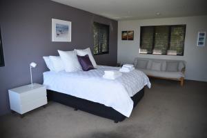 a bedroom with a large bed and a couch at Studioat10 in Hobart