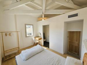 a bedroom with a white bed and a desk at Elegante maison avec un beau jardin, à 150 m de la mer, climatisation, Wifi ... in Saint-Mandrier-sur-Mer