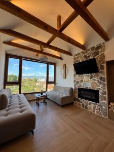 a living room with a couch and a stone fireplace at Vila Emante in Tushemisht