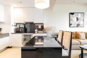 a kitchen and living room with a table and a couch at Emaar Dubai Marina Residences - formerly Address Dubai Marina in Dubai