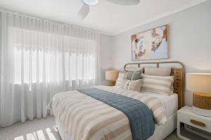 a white bedroom with a bed and a window at Miami Getaway in Gold Coast