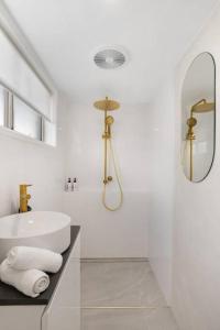 a white bathroom with a sink and a mirror at Miami Getaway in Gold Coast +13 photos
