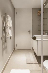 een badkamer met een witte deur en een wastafel bij Warwick 30C in Kaapstad