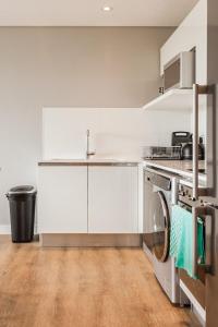 een witte keuken met een spoelbak en een vaatwasser bij Warwick 30C in Kaapstad