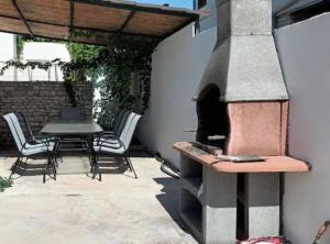a patio with an outdoor oven with a table and chairs at SPA Villa ALEMI, Private Pool, Sauna & Free Parking in Brodarica