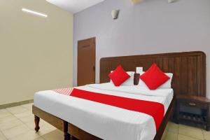 a bedroom with a large bed with red pillows at Hotel O HRR Hotels Near Paradise circle in Hyderabad
