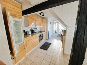 a kitchen with wooden cabinets and a tile floor at Ferienwohnung "Weit Blick" Objekt-ID 15678-6 in Neu Schloen +16 photos