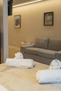 two towels on a table in a living room with a couch at HALO Vigo TRES in Vigo