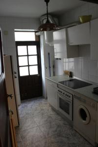 a kitchen with a stove and a sink and a door at Aires de gredos/bajo in Candeleda