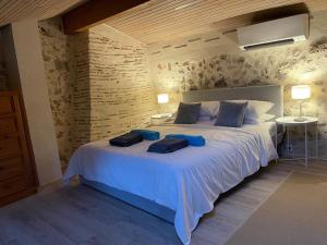a bedroom with a large white bed with blue pillows at Gites de Verger, stylish self catering cottages in Sos in Sos +25 photos