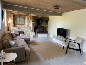 a living room with a couch and a tv at Gites de Verger, stylish self catering cottages in Sos in Sos