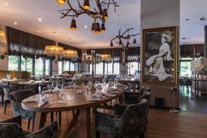 ein Restaurant mit Tischen und Stühlen und einem Bild an der Wand in der Unterkunft Schloss Basthorst in Crivitz