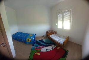 a small room with two beds and a window at Imanje Boljevic in Dubrava
