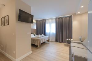 ein Hotelzimmer mit einem Bett und einem Fernseher in der Unterkunft HALO Vigo CUATRO in Vigo