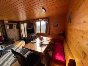 ein Esszimmer mit einem Holztisch und roten Stühlen in der Unterkunft Chalet Berken in Ernen