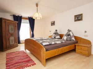 sypialnia z drewnianym łóżkiem i drewnianą komodą w obiekcie Holiday Home Schwarzenegg by Interhome w mieście Wagrain