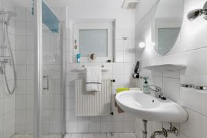 a white bathroom with a sink and a shower at Haus Gartenidylle in Wesselburen +14 photos