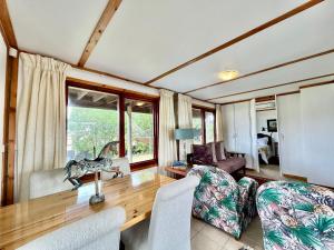 a living room with a wooden table and chairs at Lili Ellipsis in Pearly Beach