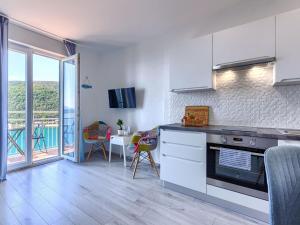 a kitchen with a stove and a table with chairs at Apartment Boris by Interhome in Raša