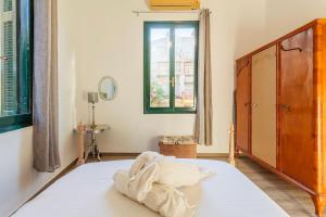 una camera da letto con un grande letto bianco con una finestra di Nafplia Guesthouse 1 a Nauplia