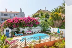 a villa with a swimming pool and pink flowers at Family Villa in Lisbon ,Heated Pool ,Elevator,Parking,6 Bedrooms,Sleeps 14 in Lisbon