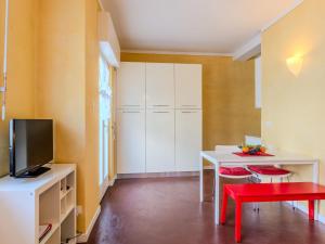 a living room with a white table and a red stool at Apartment Sole by Interhome in Claino +19 photos