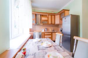 a kitchen with a table and a refrigerator at Five Stars Timiryazeva 4 in Chelyabinsk