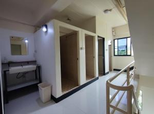 a hallway with a bathroom with a sink and a mirror at 168 Chiangmai Guesthouse in Chiang Mai