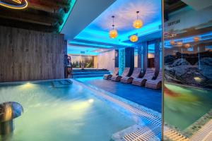 basen sportowy w hotelu z krzesłami i basenem w obiekcie Hotel Maria & Spa w mieście Szczawnica