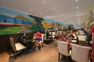 a restaurant with a mural of a train on the wall at Lakeview Backpackers Hostel & Rooftop Bar in Hanoi