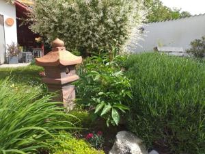 a garden with a bird house in the grass at Apponyi Guesthouse 49 in Kaposvár