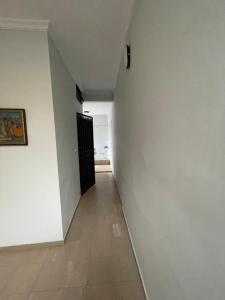 a hallway with a black door and a white wall at Mermoz Dakar in Dakar +1 photo