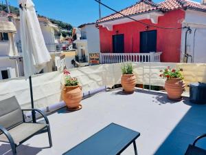 a patio with four potted plants inront of a house at Old Town Studios in Parga