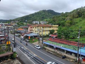 a city street with a mountain in the background at Karon Living Room - SHA Plus in Karon Beach