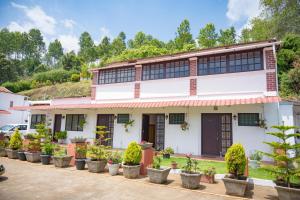 una casa con piante in vaso davanti di Trilan Cottages - Donnington Road a Kotagiri