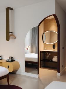 een hotelkamer met een bed en een spiegel bij Conscious Hotel Museum Square in Amsterdam