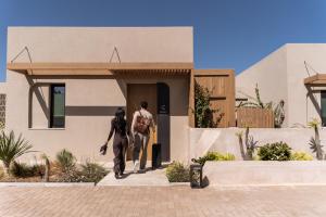 a man and woman walking out of a house at Heraklion Cicada Suites & Villas in Karteros