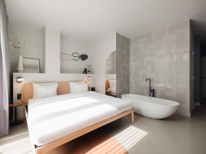 een slaapkamer met een groot bed en een bad bij Conscious Hotel Museum Square in Amsterdam