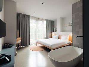 een hotelkamer met een bed en een bad bij Conscious Hotel Museum Square in Amsterdam