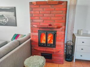 ein gemauerter Kamin in der Ecke eines Wohnzimmers in der Unterkunft Holiday Home Hovitahko a 1 by Interhome in Tahkovuori