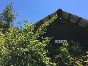um sinal que lê a terra num edifício com árvores em Crackenback Farm Guesthouse em Crackenback